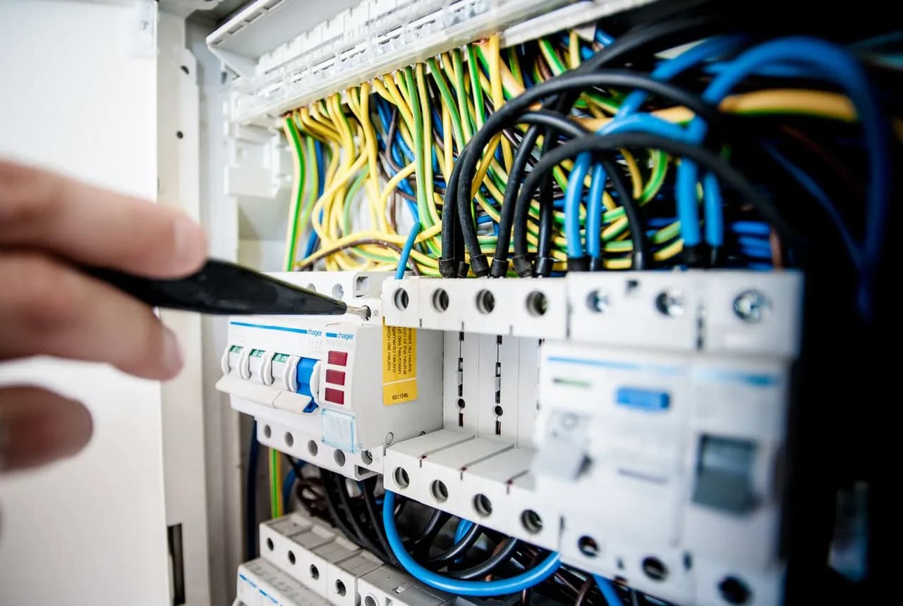 Electrician working inside an electrical switchboard
