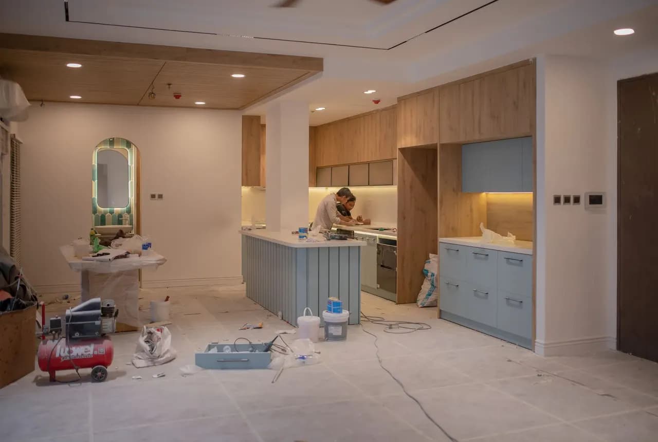 Kitchen renovation with trades working around cabinets and tools